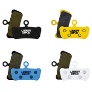 Set of Uberbike brake pads in black, yellow, blue, and white on a white background.