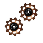 two bronze ceramic 11 tooth jockey wheels on a white background