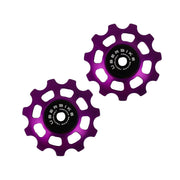two purple ceramic 11 tooth jockey wheels on a white background