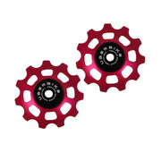 two red ceramic 11 tooth jockey wheels on a white background