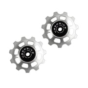 two silver ceramic 11 tooth jockey wheels on a white background