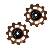 two bronze steel 11 tooth jockey wheels on a white background