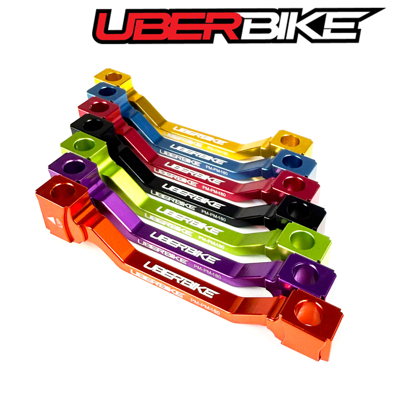 Colorful disc brake rotor adaptors with Uberbike branding on a white background.