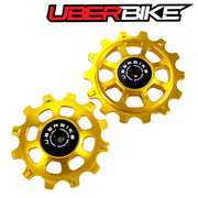 Two gold colour Ceramic pulley wheels with Uberbike logo on a white background.