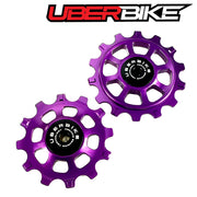 Two purple ceramic pulley wheels with Uberbike logo on a white background.