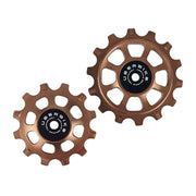 one ceramic bronze 12 tooth and one 14 tooth jockey wheel on a white background