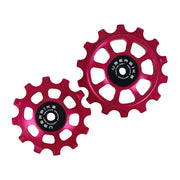 one ceramic red 12 tooth and one 14 tooth jockey wheel on a white background