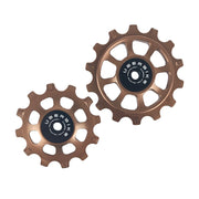one bronze stel 12 tooth and one 14 tooth jockey wheel on a white background