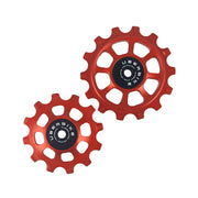 one orange steel 12 tooth and one 14 tooth jockey wheel on a white background