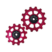 one red steel 12 tooth and one 14 tooth jockey wheel on a white background