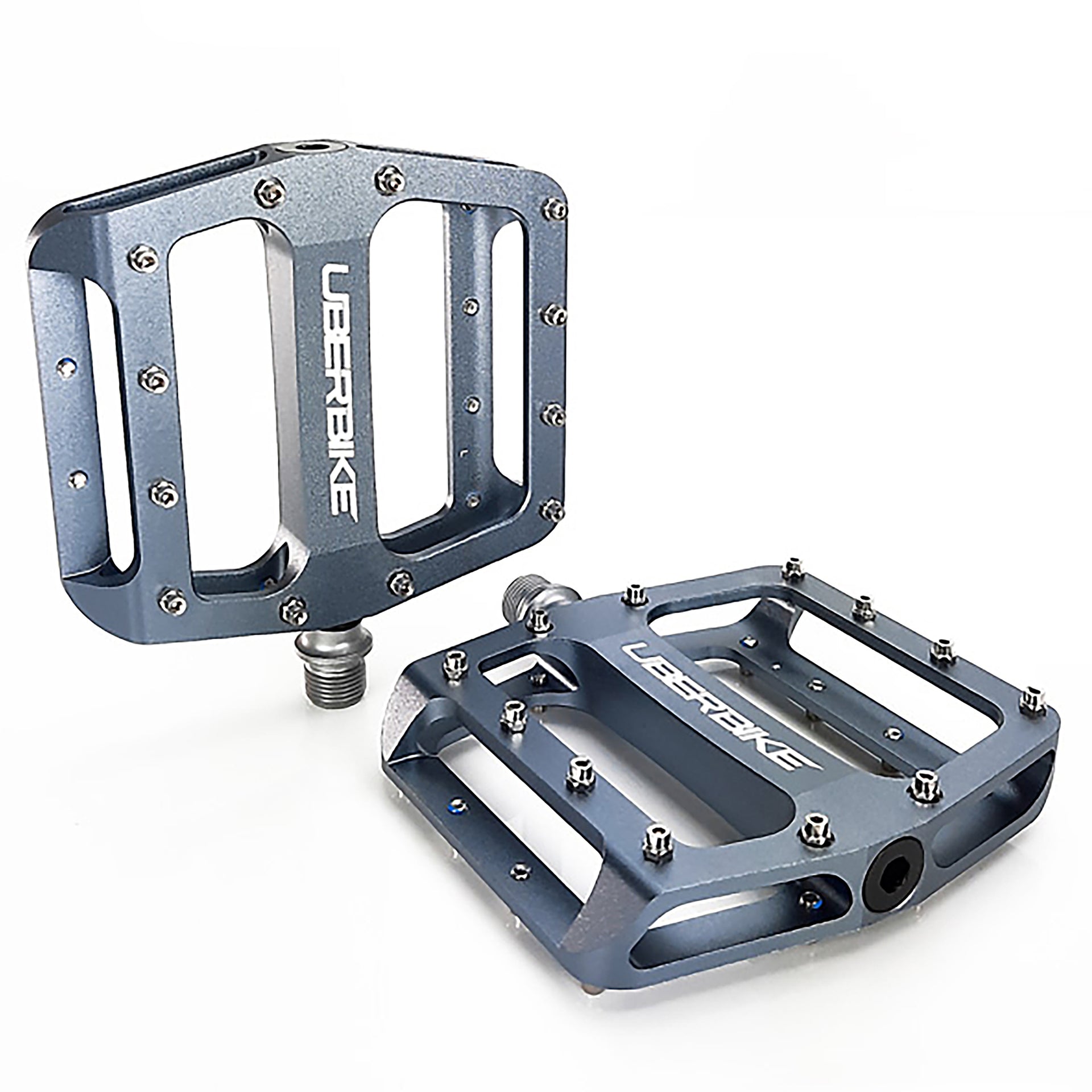 two graphite coloured pedals with raw pedal pins on a white background