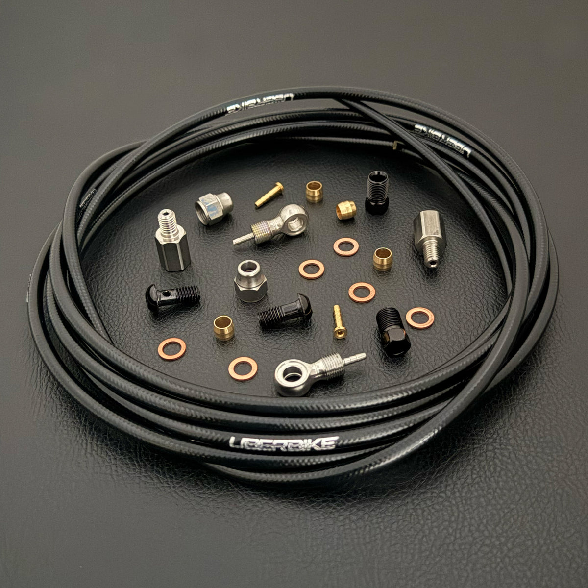 Hope tech 4 v4 black kevlar hydraulic brake hose kit with banjo fittings and Uberbike branding on a black background