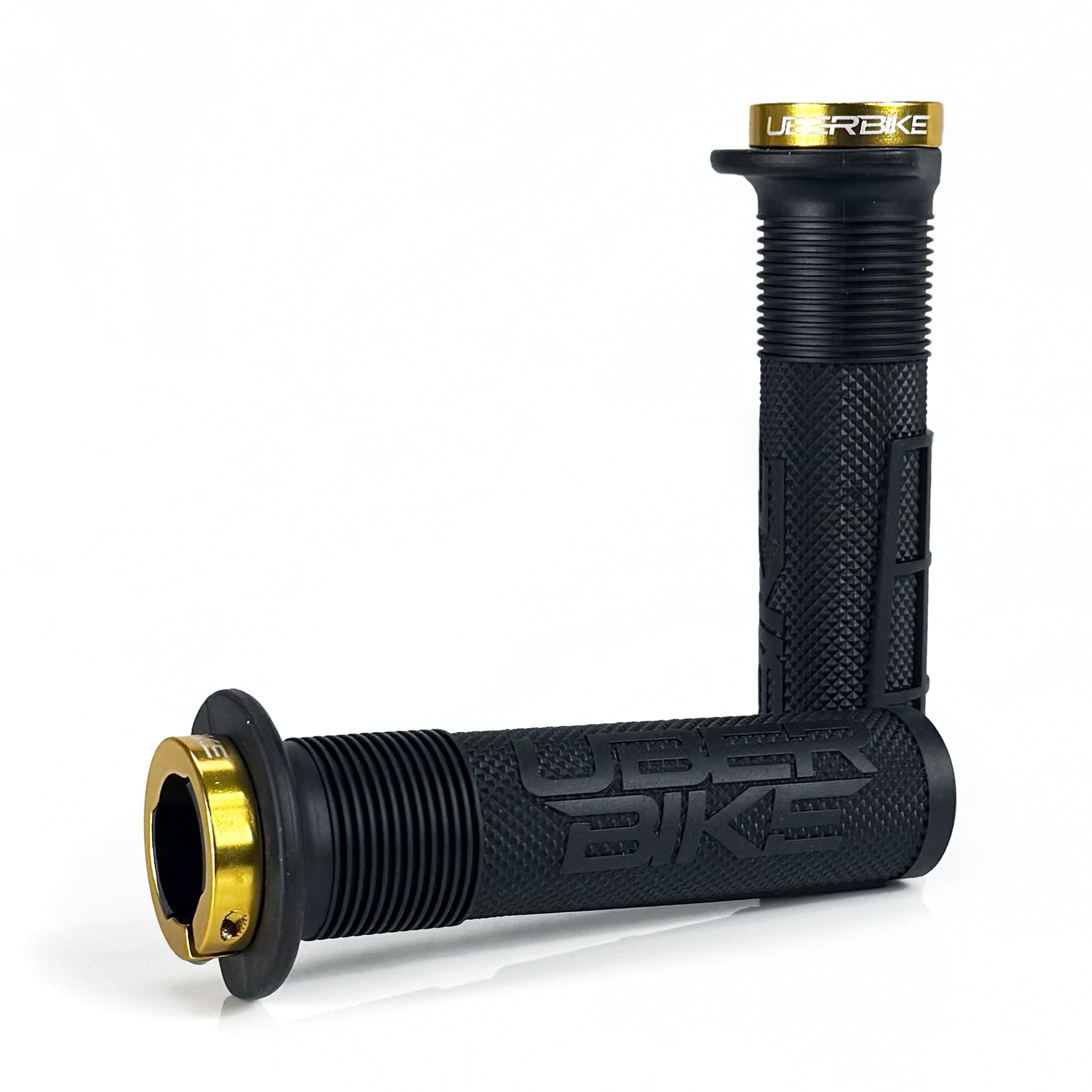 two black mushroom waffle mountain  bike grips and gold lockrings on a white background
