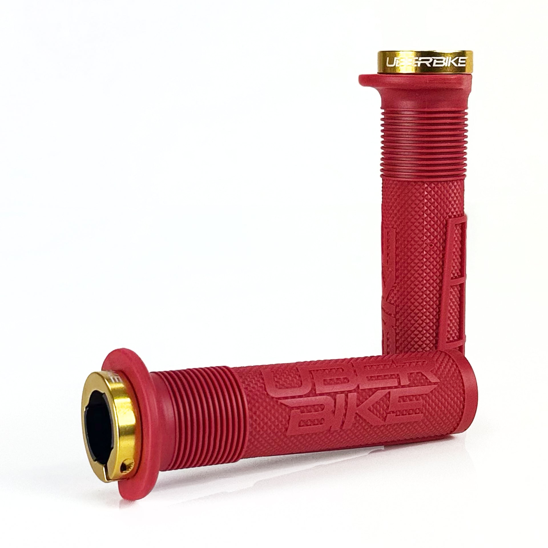 two red mushroom waffle mountain  bike grips and gold lockrings on a white background
