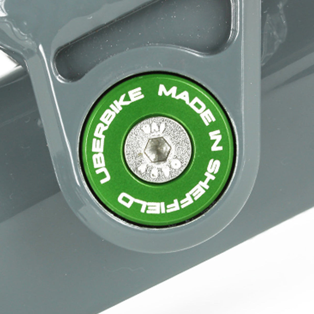 Close-up of a green 'Uberbike Made in Sheffield' Pivot bearing cap in a bike frame