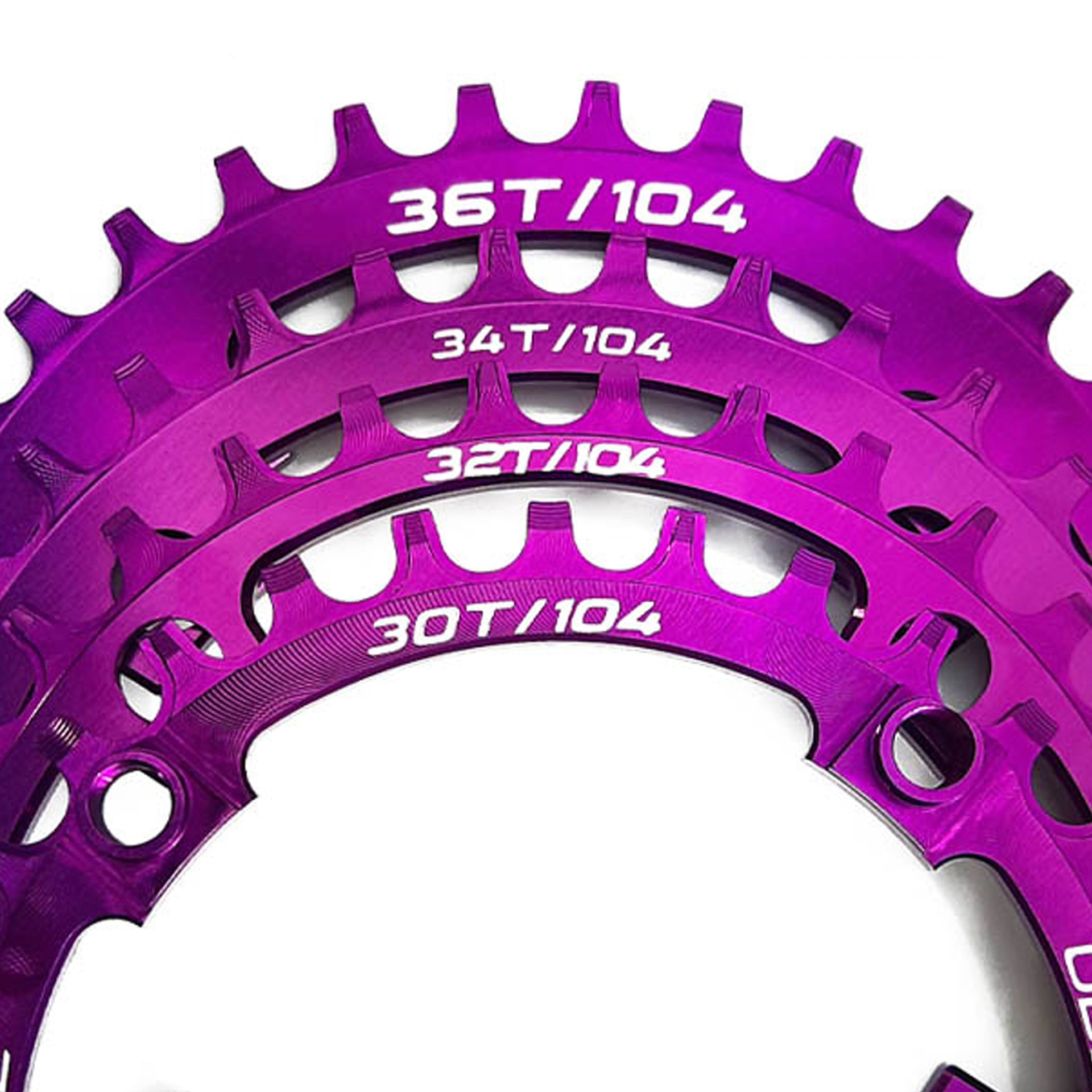 Close-up of a purple bicycle chainring with various tooth counts on a white background