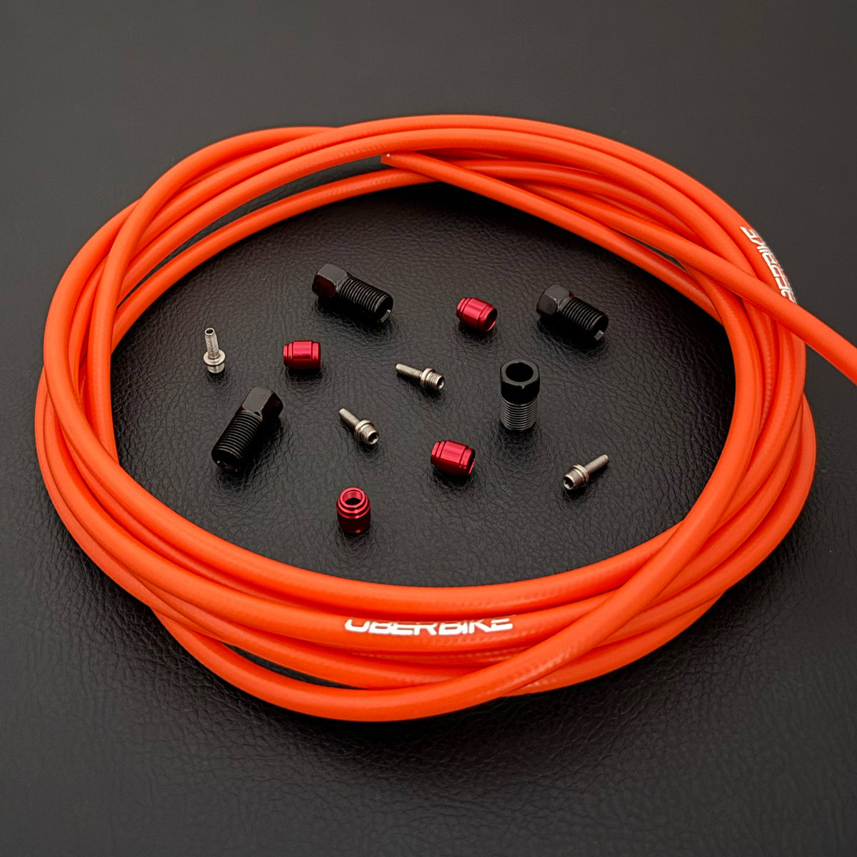 SRAM Code Stealth Bronze hydraulic orange brake hose kit with straight connector stealthmajig fittings and Uberbike branding on a black background