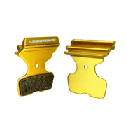 gold finned sram code silver stealth disc brake pads on a white background