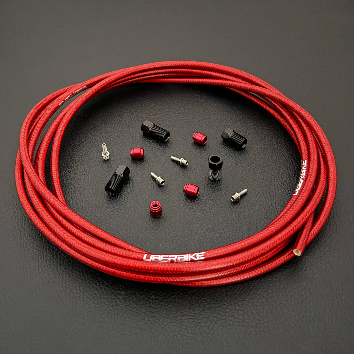 SRAM Level T hydraulic red braid kevlar brake hose kit with straight connector stealthmajig fittings and Uberbike branding on a black background