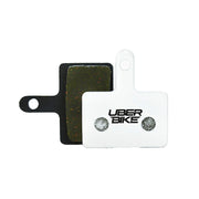 White Shimano Deore M515 disc brake pads on a white background with Uberbike branding 