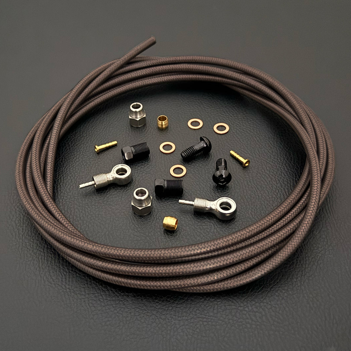 Shimano Deore XT smoke braid hydraulic brake hose kit with banjo fittings with Uberbike branding on a black background