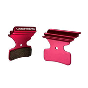 Red finned Shimano M8120 disc brake pads on a white background