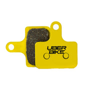 Yellow Shimano MT805 brake pads with Uberbike branding on a white background