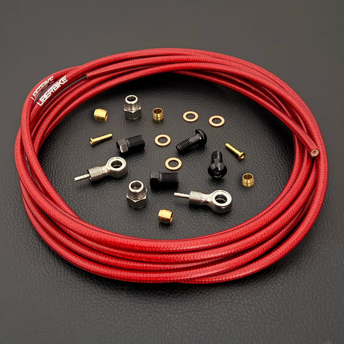 Shimano XTR red braid kevlar hydraulic brake hose kit with banjo fittings and Uberbike branding on a black background