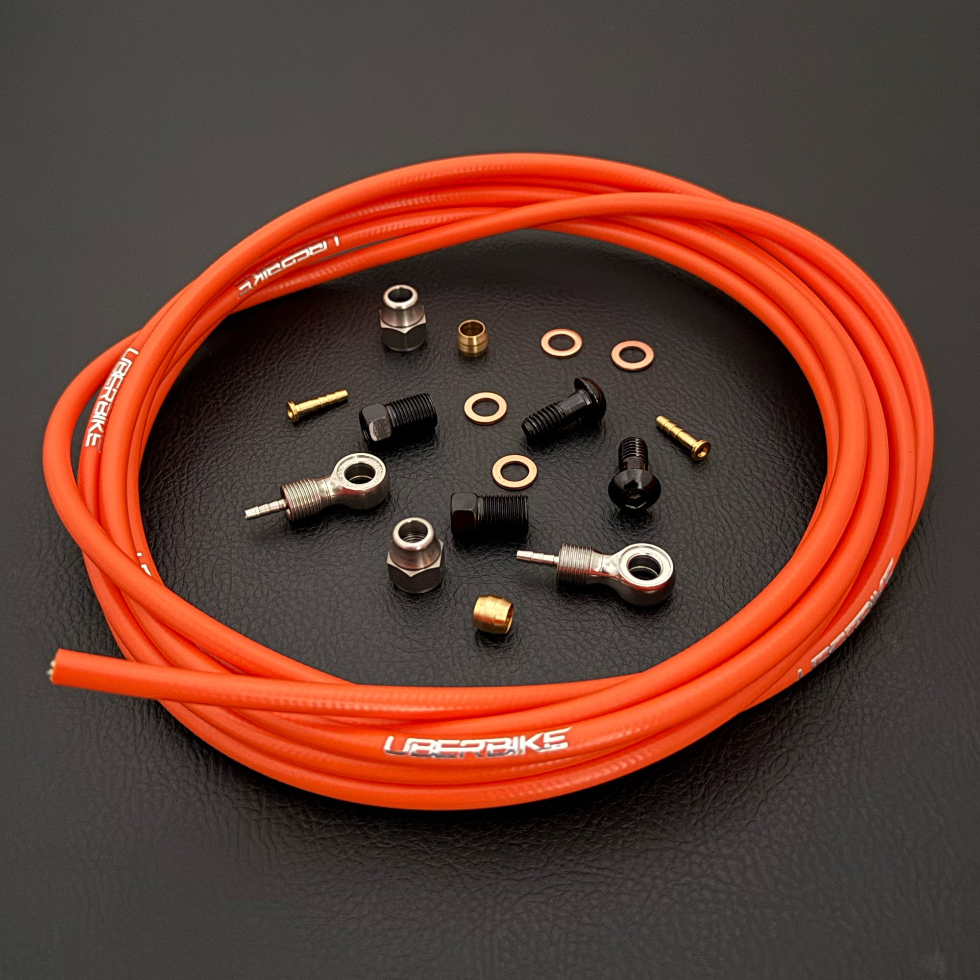 Shimano xtr hydraulic orange kevlar brake hose kit with banjo fittings and Uberbike branding on a white background