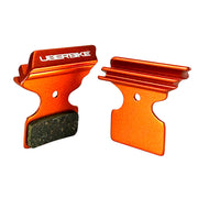 orange finned Shimano XTR M9020 brake pads on a white background