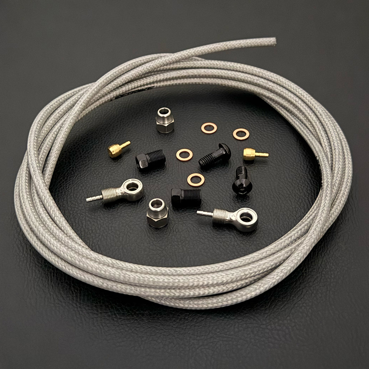 Shimano deore xt hydraulic silver braid stainless brake hose kit with banjo fittings and Uberbike branding on a black background