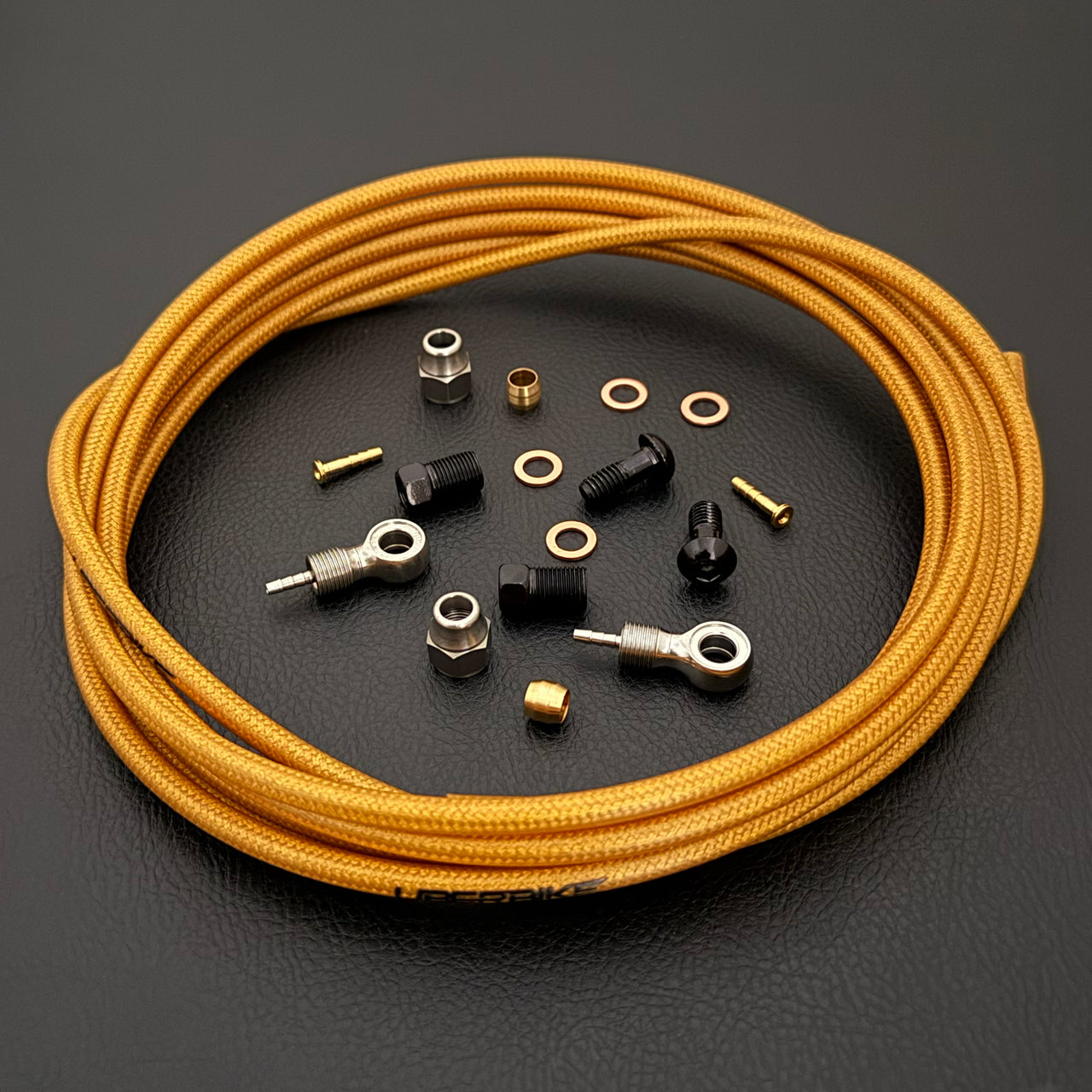 Shimano xtr hydraulic gold braid  kevlar brake hose kit with banjo fittings and Uberbike branding on a white background