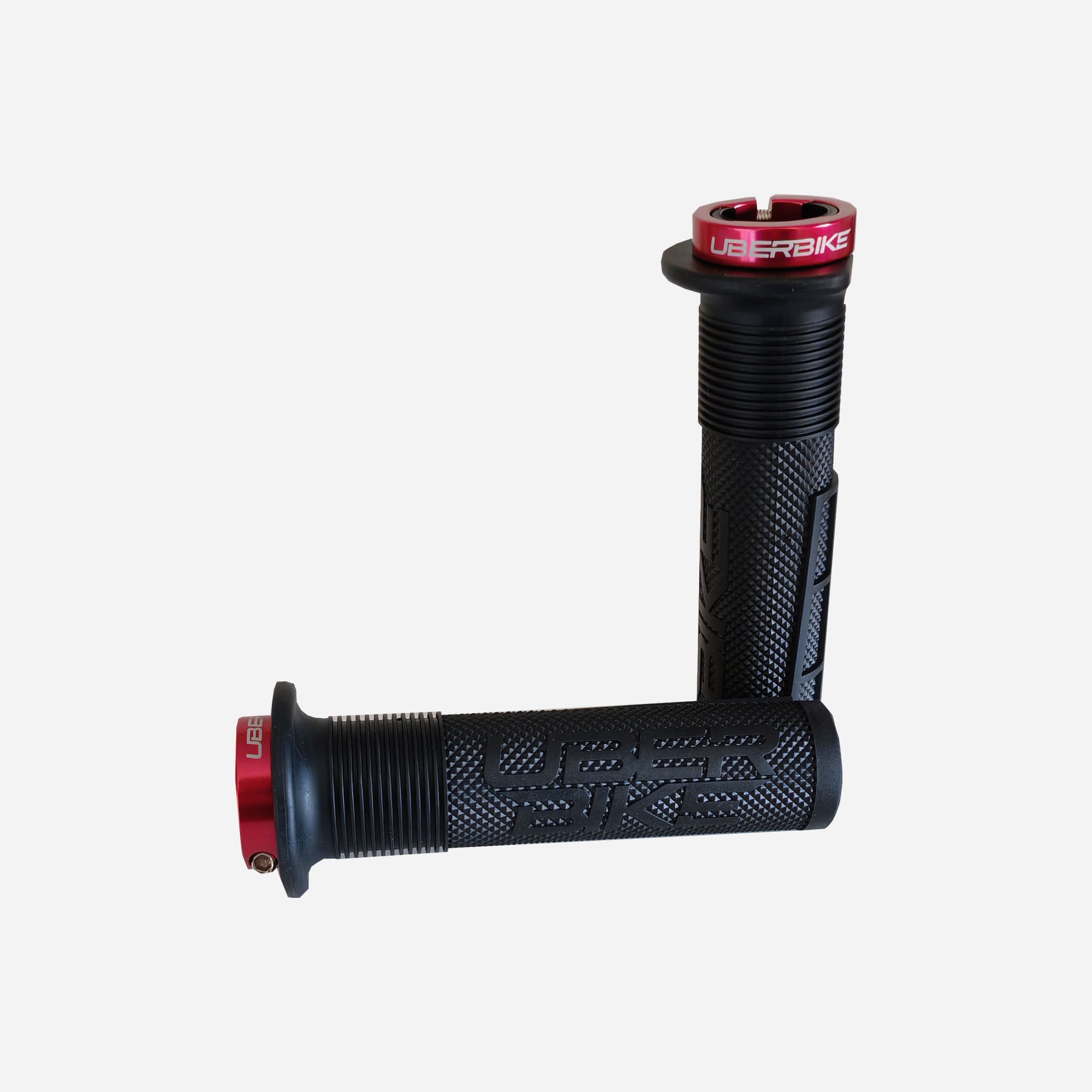 2 black mushroom mountain bike grips with red lockrings and uberbike branding on a white background