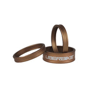 3 bronze headset spacers with Uberbike branding on a white background