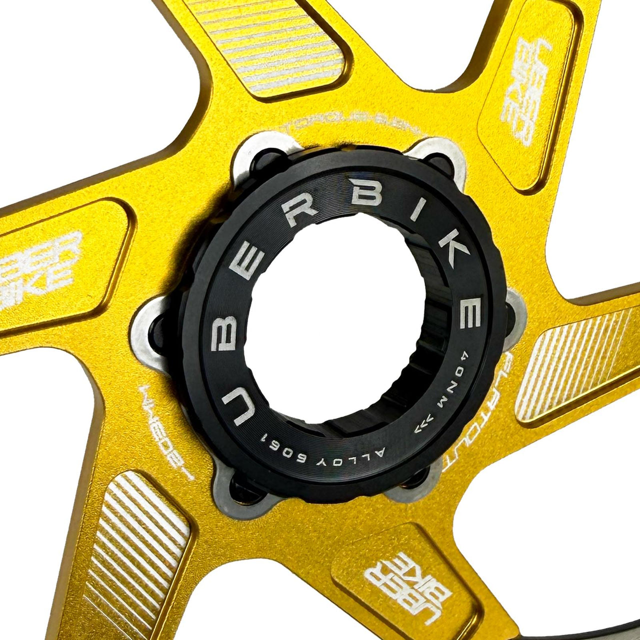 Gold and black bicycle centre lock adapter with 'Uberbike' branding on a white background