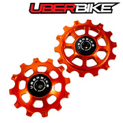 Two orange ceramic pulley wheels with 'Uberbike' branding on a white background.