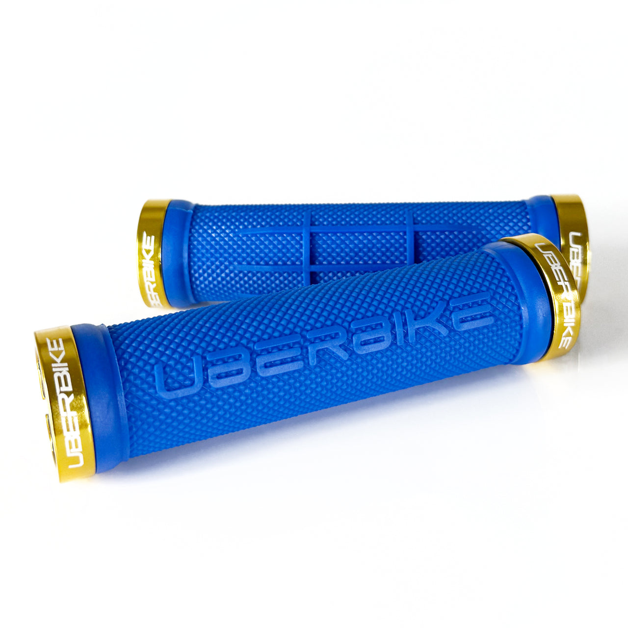 two blue half waffle mountain  bike grips and gold lockrings on a white background