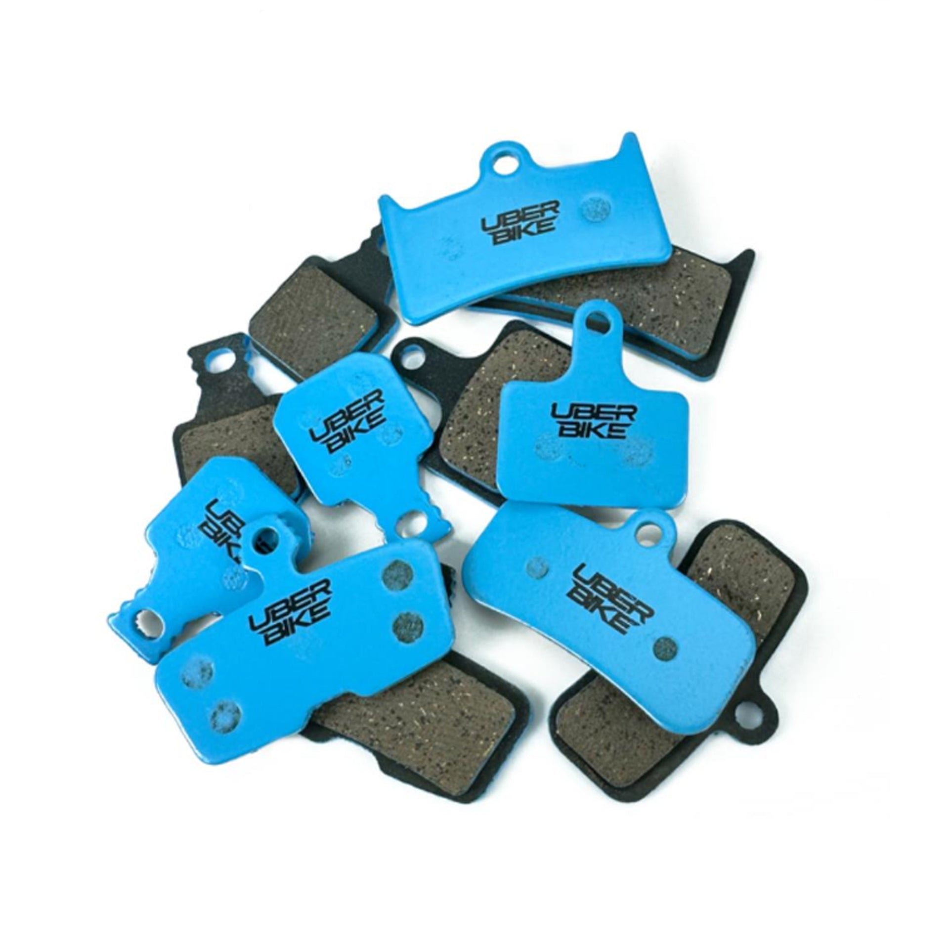Pile of blue Uberbike brake pads on a white background, out of packaging
