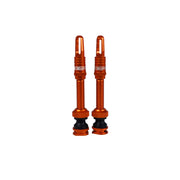 two orange airtech valves on a white background with Uberbike branding 
