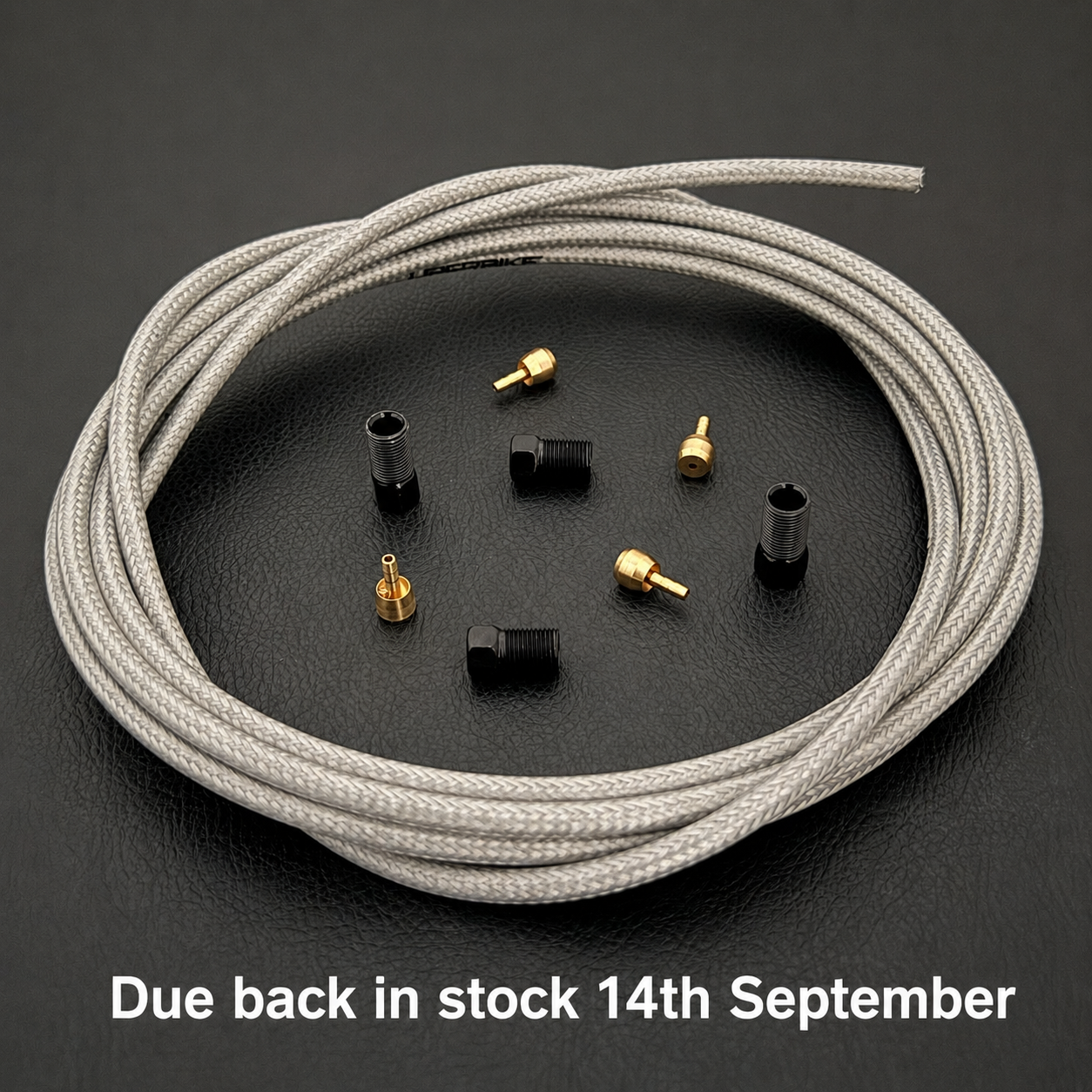 A coiled light silver braided shimano xtr brake cable with straight connector fittings. White text at the bottom reads 'Due back in stock 14th September'