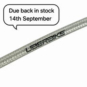 A close-up of a silver braided SRAM silver cable with the brand name 'UBERBIKE' printed on it, set against a plain white background with a speech bubble stating 'Due back in stock 14th September'.